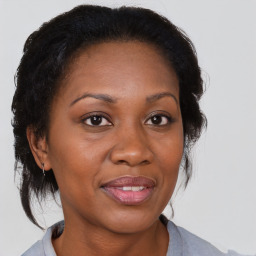 Joyful black adult female with medium  brown hair and brown eyes