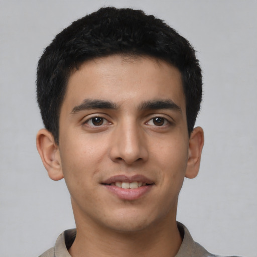 Joyful latino young-adult male with short  black hair and brown eyes