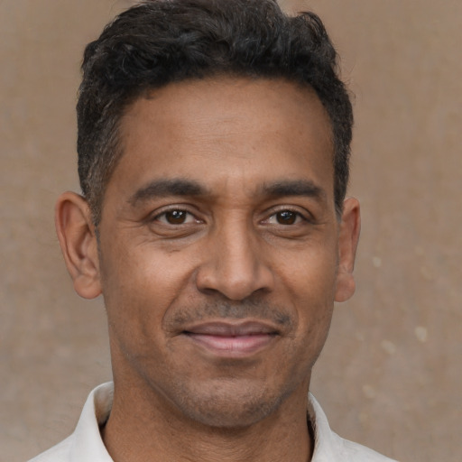 Joyful latino adult male with short  black hair and brown eyes