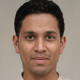 Joyful latino young-adult male with short  black hair and brown eyes