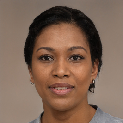 Joyful black young-adult female with short  black hair and brown eyes