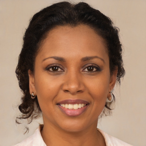 Joyful latino adult female with medium  brown hair and brown eyes