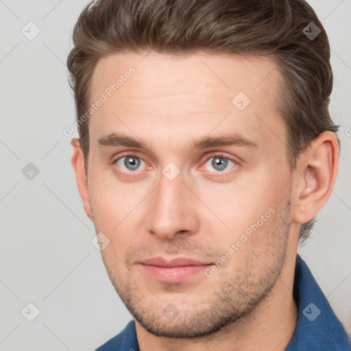 Joyful white young-adult male with short  brown hair and grey eyes