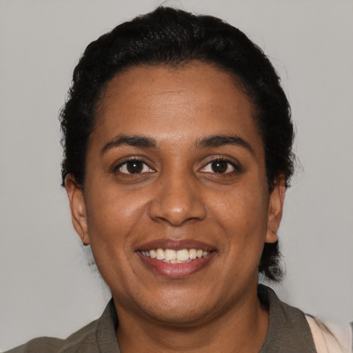 Joyful black adult female with short  black hair and brown eyes