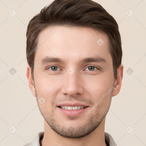 Joyful white young-adult male with short  brown hair and grey eyes