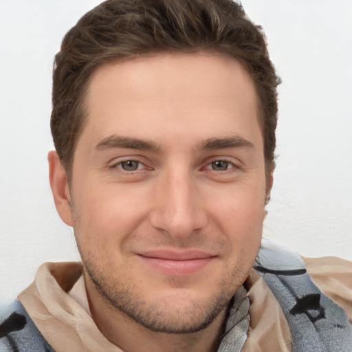 Joyful white young-adult male with short  brown hair and grey eyes