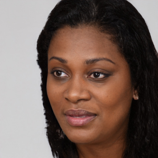 Joyful black young-adult female with long  black hair and brown eyes