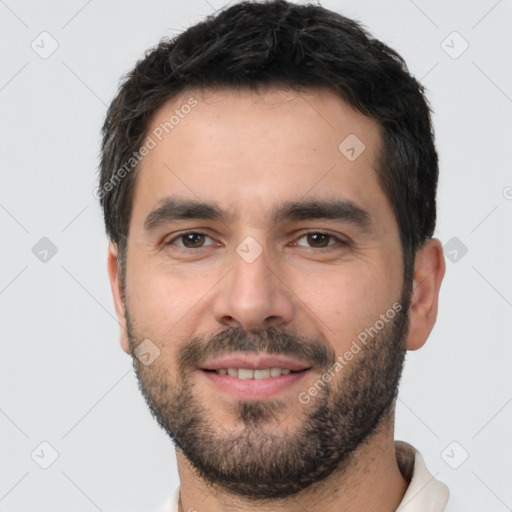 Joyful white young-adult male with short  black hair and brown eyes