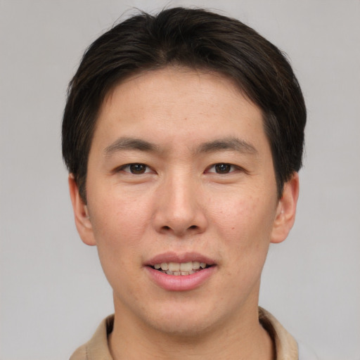 Joyful asian young-adult male with short  brown hair and brown eyes
