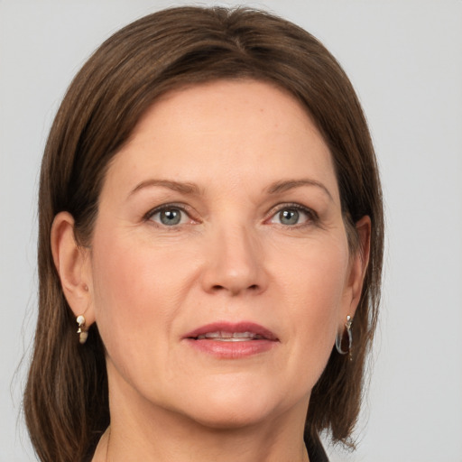 Joyful white adult female with medium  brown hair and grey eyes