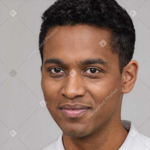 Joyful black young-adult male with short  black hair and brown eyes