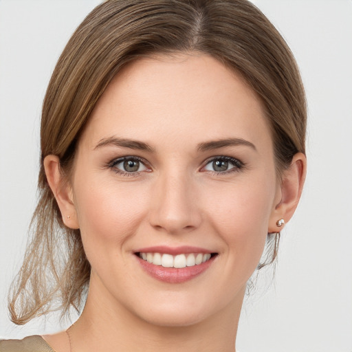 Joyful white young-adult female with medium  brown hair and grey eyes