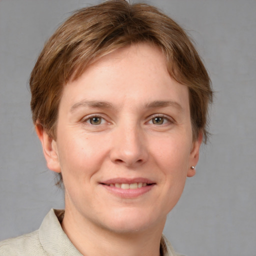 Joyful white young-adult female with short  brown hair and grey eyes