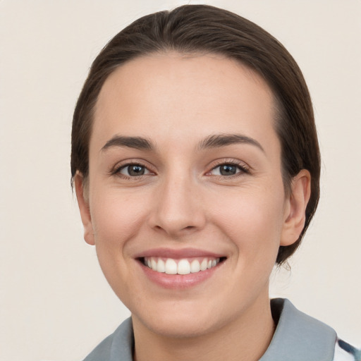 Joyful white young-adult female with short  brown hair and grey eyes