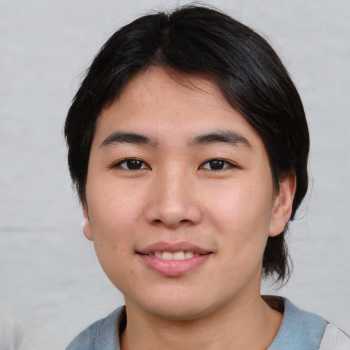 Joyful asian young-adult male with medium  black hair and brown eyes