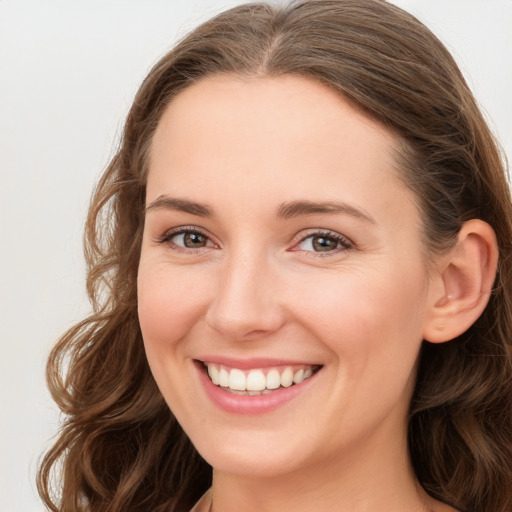 Joyful white young-adult female with long  brown hair and green eyes