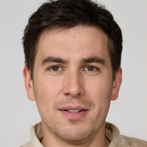 Joyful white young-adult male with short  brown hair and grey eyes