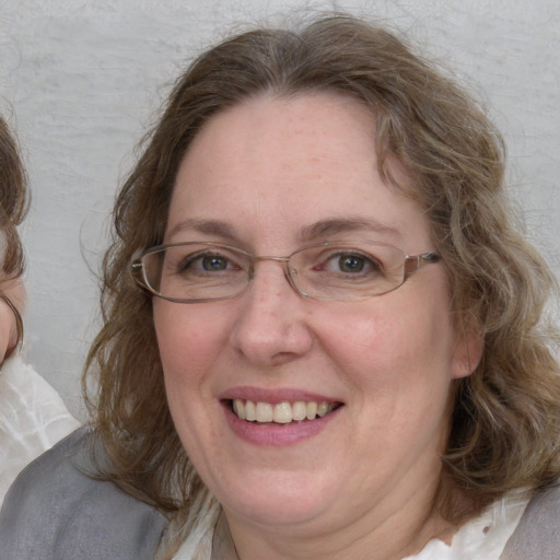 Joyful white adult female with medium  brown hair and blue eyes