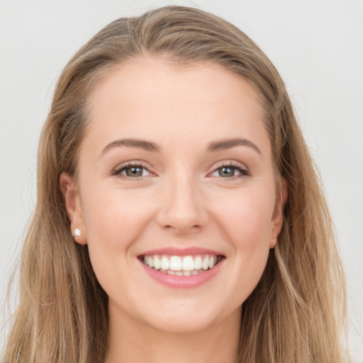 Joyful white young-adult female with long  brown hair and grey eyes