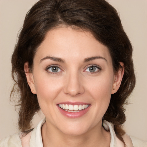 Joyful white young-adult female with medium  brown hair and green eyes