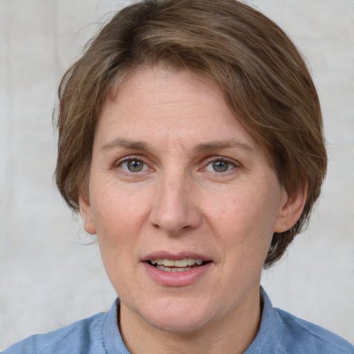 Joyful white adult female with medium  brown hair and blue eyes