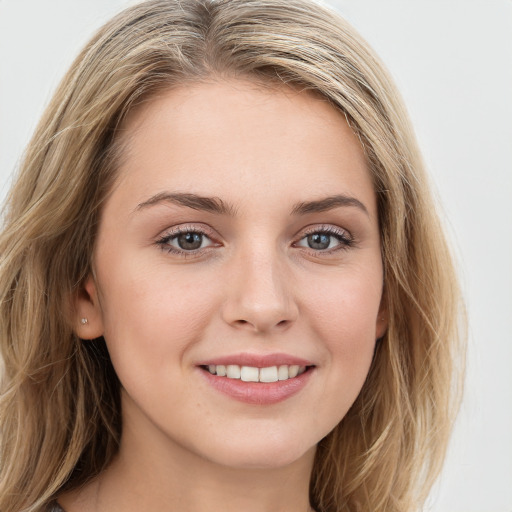 Joyful white young-adult female with long  brown hair and blue eyes