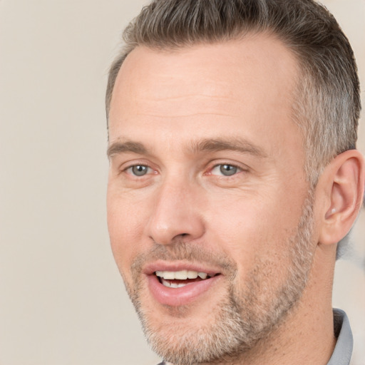 Joyful white adult male with short  brown hair and brown eyes