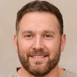 Joyful white adult male with short  brown hair and brown eyes