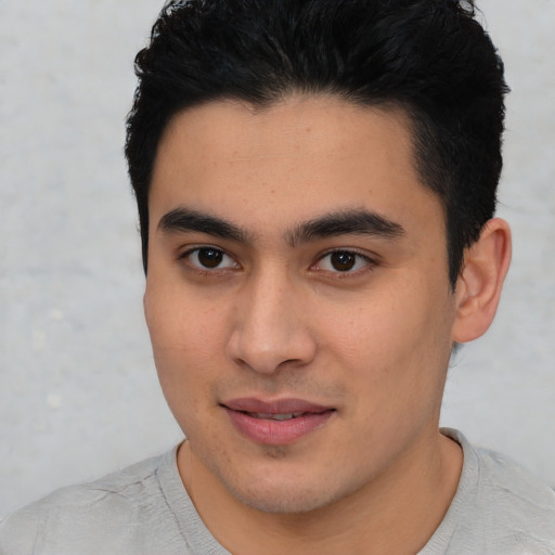 Joyful latino young-adult male with short  black hair and brown eyes