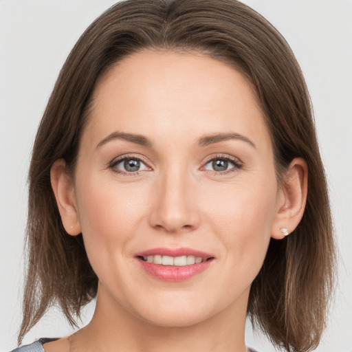 Joyful white young-adult female with medium  brown hair and grey eyes