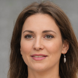 Joyful white young-adult female with long  brown hair and green eyes