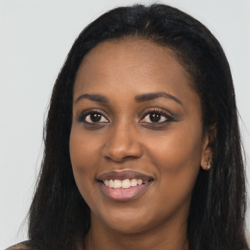 Joyful black young-adult female with long  black hair and brown eyes