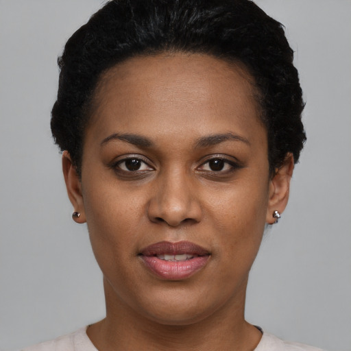 Joyful black young-adult female with short  black hair and brown eyes