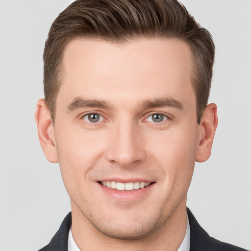 Joyful white young-adult male with short  brown hair and grey eyes