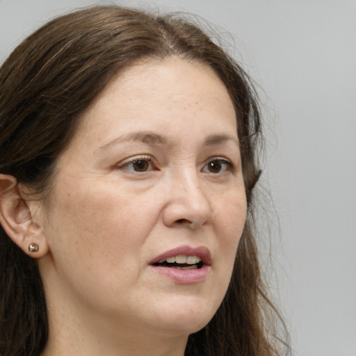 Joyful white adult female with long  brown hair and grey eyes