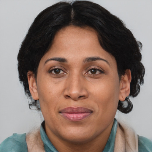 Joyful latino adult female with medium  brown hair and brown eyes