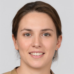 Joyful white young-adult female with medium  brown hair and grey eyes