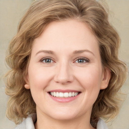 Joyful white young-adult female with medium  brown hair and green eyes