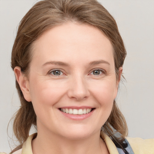 Joyful white young-adult female with medium  brown hair and blue eyes