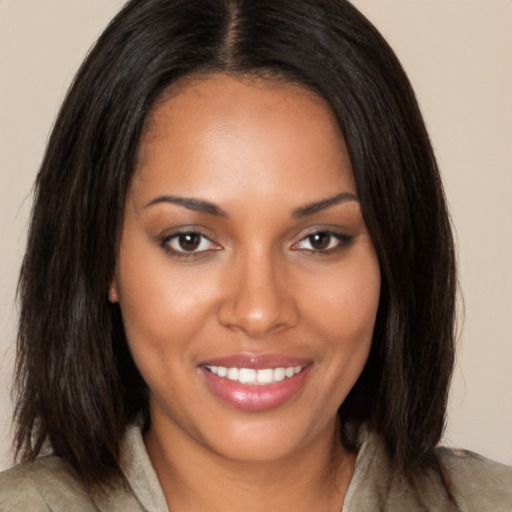 Joyful black young-adult female with long  brown hair and brown eyes