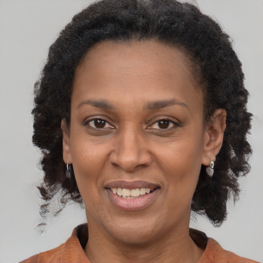 Joyful black adult female with short  brown hair and brown eyes