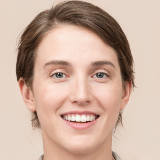 Joyful white young-adult female with medium  brown hair and grey eyes