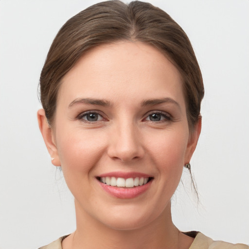 Joyful white young-adult female with medium  brown hair and grey eyes