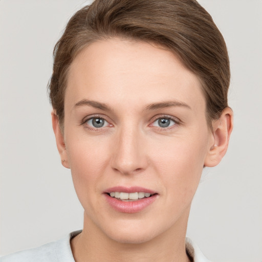 Joyful white young-adult female with short  brown hair and grey eyes