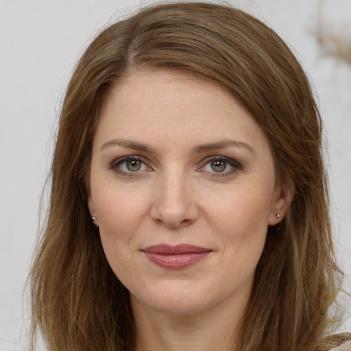 Joyful white young-adult female with long  brown hair and green eyes