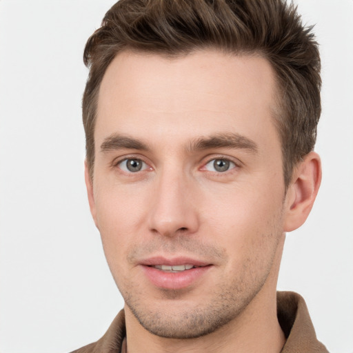 Joyful white young-adult male with short  brown hair and grey eyes