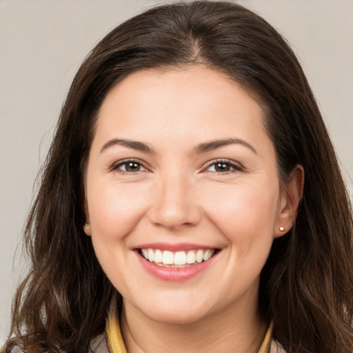 Joyful white young-adult female with long  brown hair and brown eyes