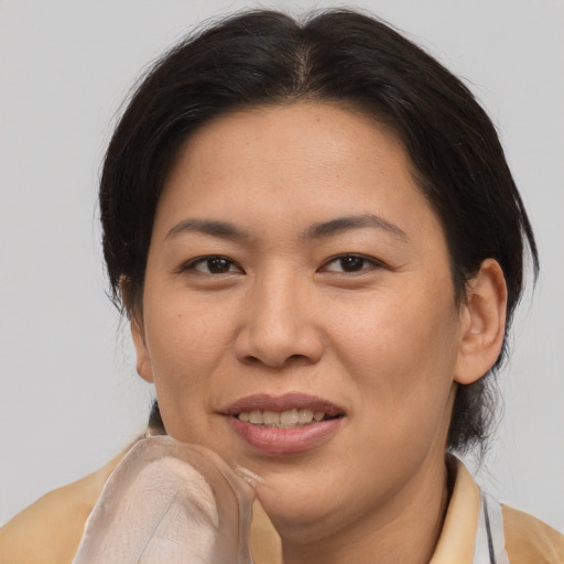 Joyful asian adult female with medium  brown hair and brown eyes