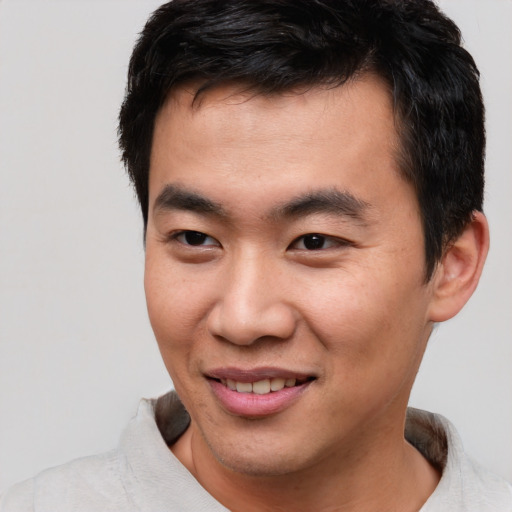Joyful asian young-adult male with short  black hair and brown eyes