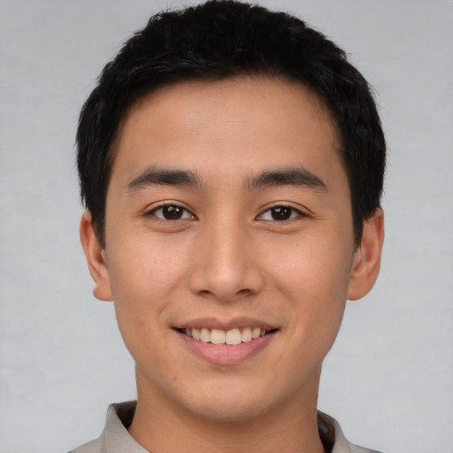 Joyful asian young-adult male with short  black hair and brown eyes